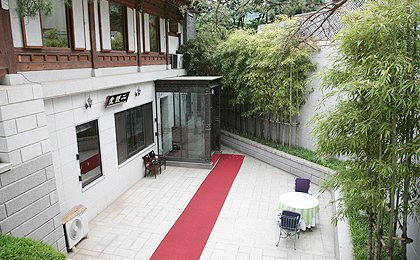 흰 벽 건물 입구와 붉은 카펫(낮)